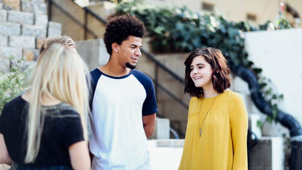 women and man talking outside the building