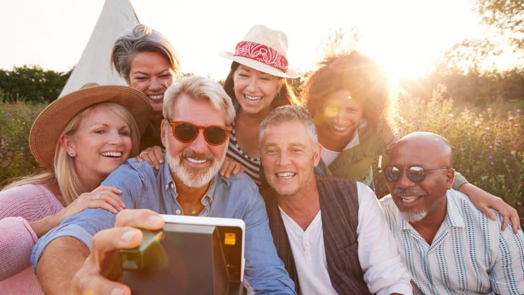 Group Of Mature Friends Posing For Selfie At Outdoor Campsite