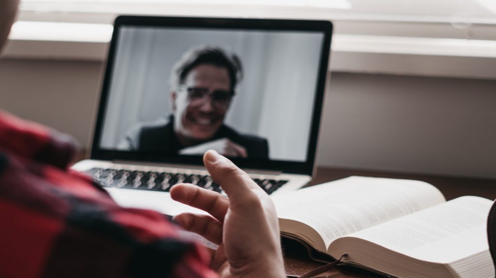 person in red and black plaid long sleeve shirt using black laptop computer