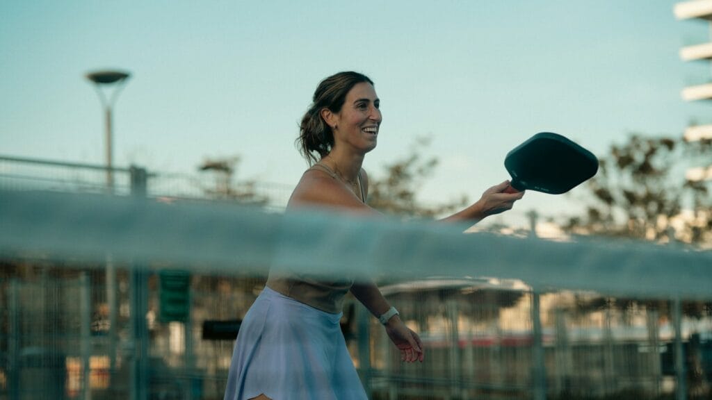 A woman holding a tennis racquet on top of a tennis court