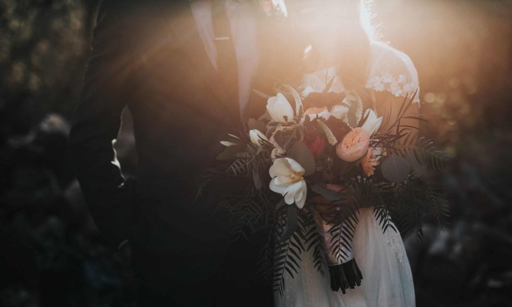 groom beside bride holding bouquet flowers